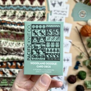 Æske med Woodland-strikkedoodlekort foran kort og strik med skovmotiver