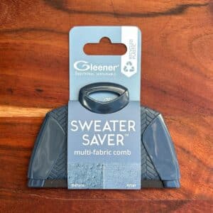 Blå Gleener Sweater Saver uldkam i emballage på træbord
